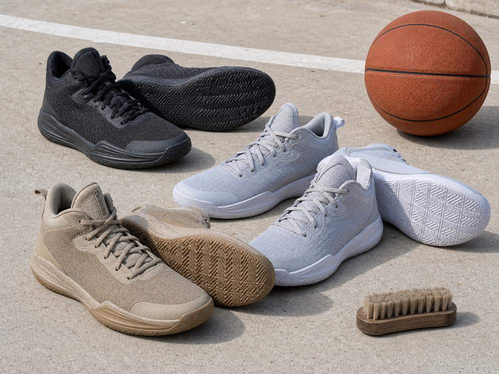 Three unbranded basketball shoe pairs with thick rubber outsoles on rough concrete