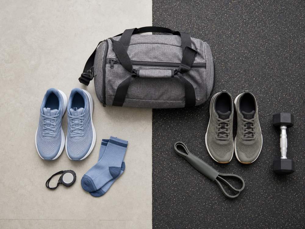 Unbranded running shoes and training shoes arranged on separate cardio and gym floor surfaces