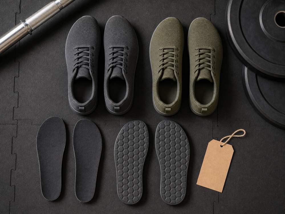 Generic training shoes insoles and flat rubber outsoles arranged on a lifting platform